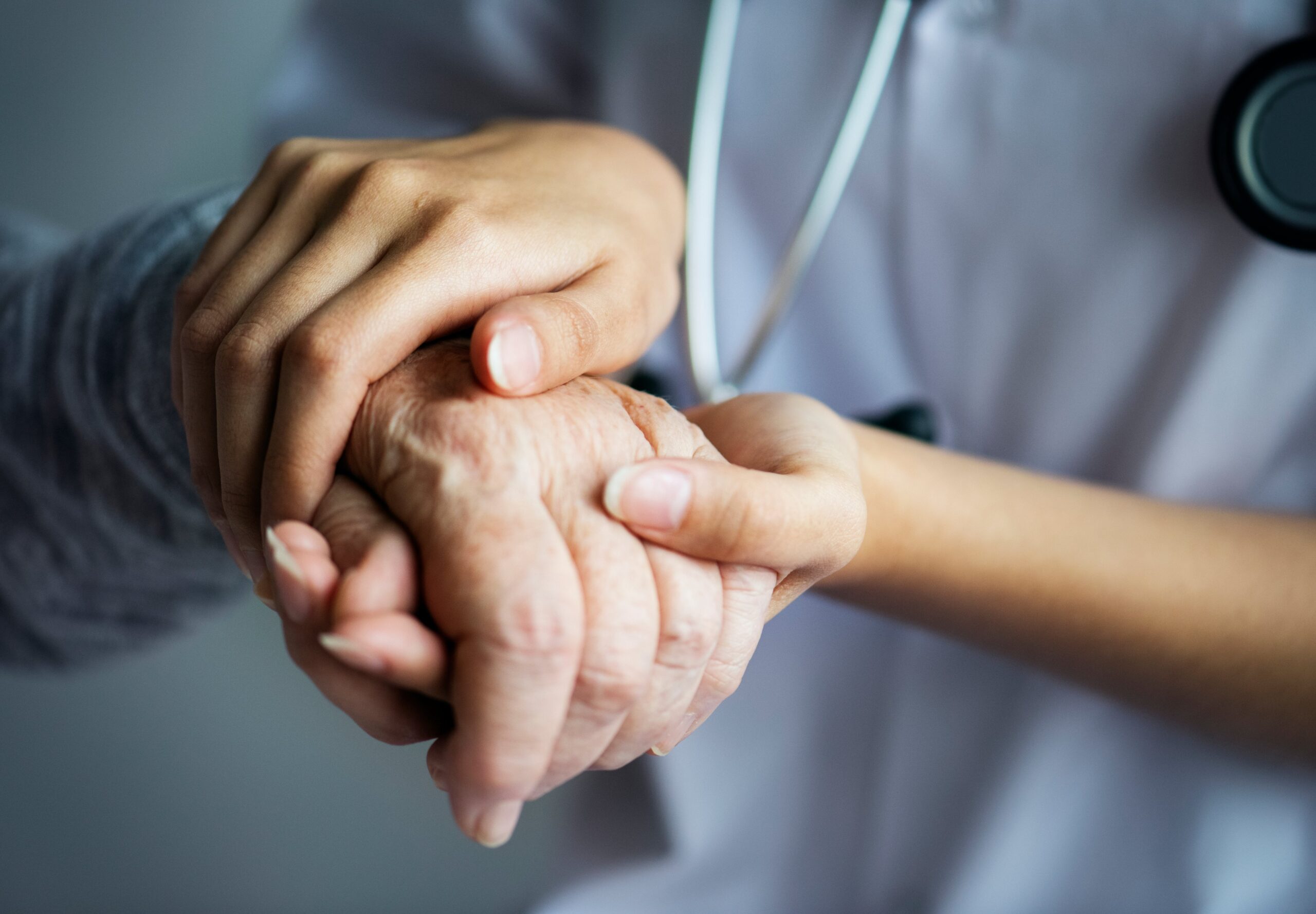 Nurse holding the hand of an elderly - palliative care